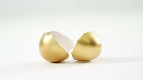 Cracked Golden Eggshell on White Background