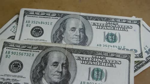 Pile of One Hundred Dollar Bills on Surface