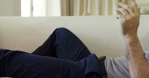 Adult Lying on Couch Talking on Smartphone