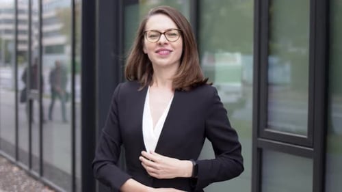 Confident Woman Smiling in Front of Office Building