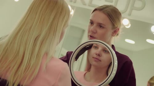 Makeup Artist Working on Young Woman's Eyebrows