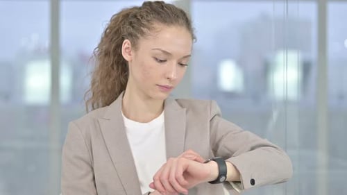 Young Adult Woman Uses Smart Watch in Office