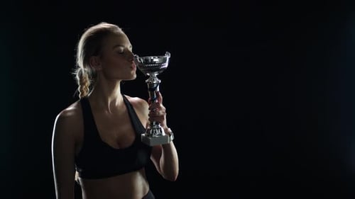 Sport Woman Winner Kissing Champion Trophy in Slow Motion. Woman Champion