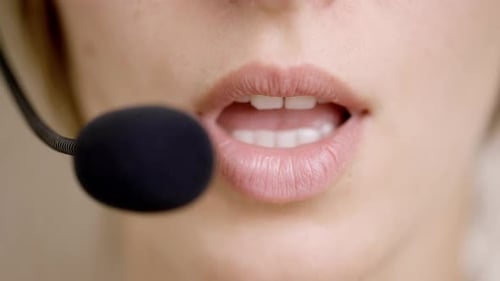 A Business Woman Talking on Headset with Microphone in Call Center