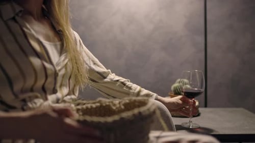 Close Up Woman Relaxing at Night Drinking Wine and Crocheting