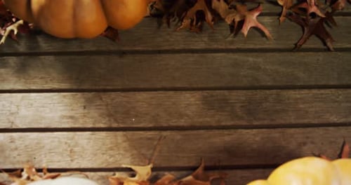 Pumpkins and Autumn Leaves on Wooden Table