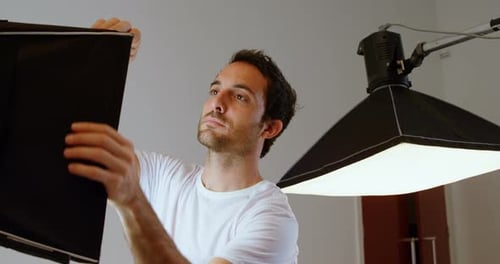 Photographe de sexe masculin ajustant la lumière stro