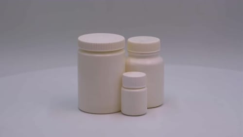 Three Pill Bottles of Different Sizes on White