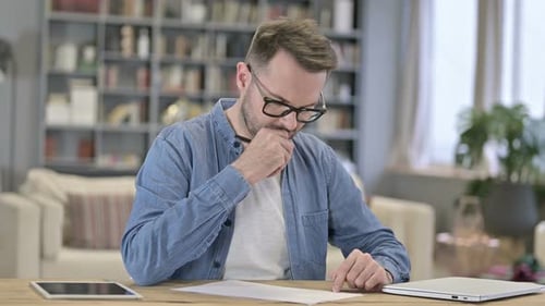 Professional Young Man Writing on Paper in Loft Office