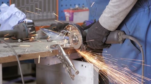 Ein Arbeiter arbeitet mit Grinder. Hands Of Workman Schneiden von Metalldetails mit Schleifmaschine