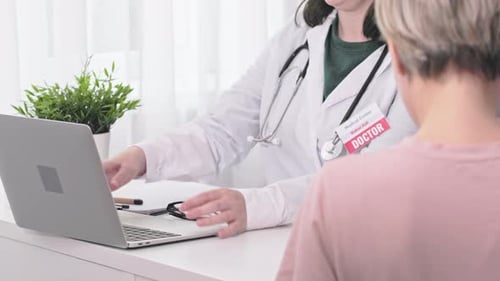 Doctor and Patient in Clinic Office During Appointments Visit Opening Laptop