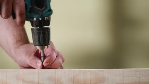 Drill Driving Screw into Wood Plank Close Up