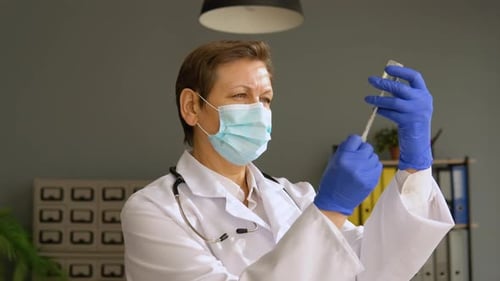 Medical Professional Drawing Vaccine with Syringe