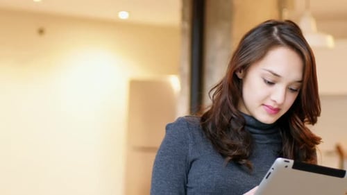 Young Woman Uses Tablet Device Indoors