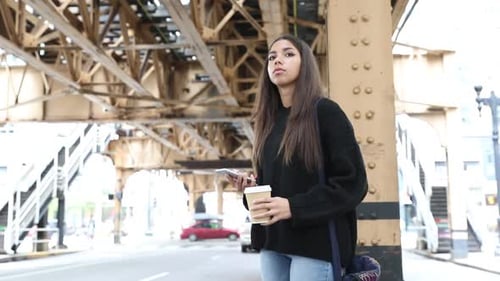 Girl waving hand with phone hailing taxi