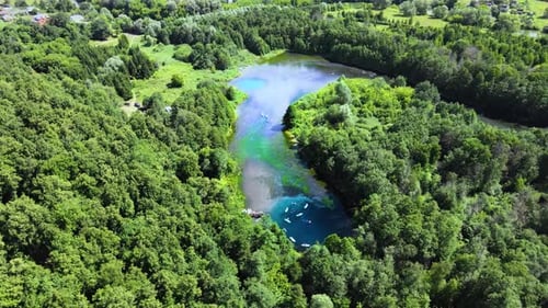 Standup paddleboarding on a winding forest river. Vacationers float downstream