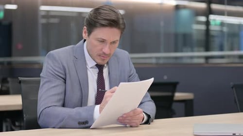 Man Writing Document in Office