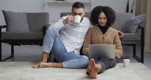 Couple Relaxing at Home Using Laptop Together