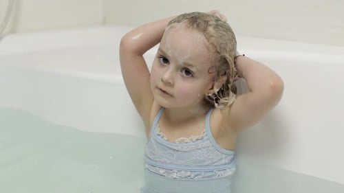 Girl Washing Hair in Bathtub with Shampoo