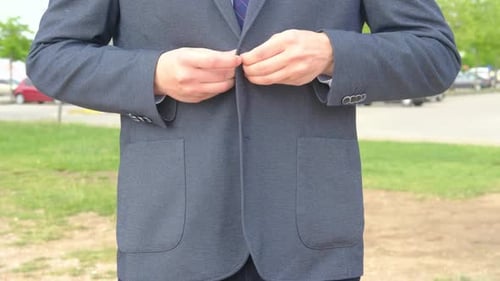 Young Man Buttons Jacket in Urban Setting
