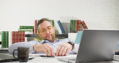 Procrastination Concept Middleaged Man is Lounging in the Office He Makes a Paper Airplane and