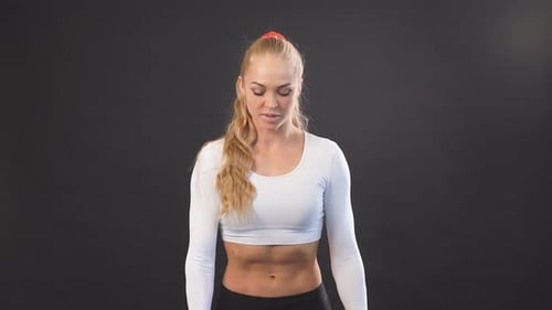 Serious Woman in Stylish Sportswear Working Out with Dumbbells