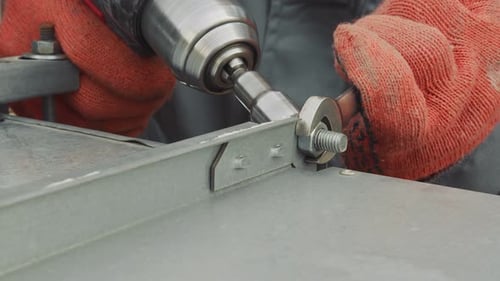 Worker Tightening Bolt with Power Drill Close Up