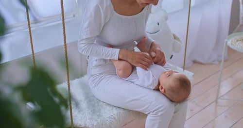 Loving Mother Interacting with Infant on Swing