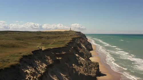 Coastal Cliffs and Lighthouse by Turquoise Sea