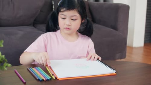 Girl Drawing with Colored Pencils Indoors