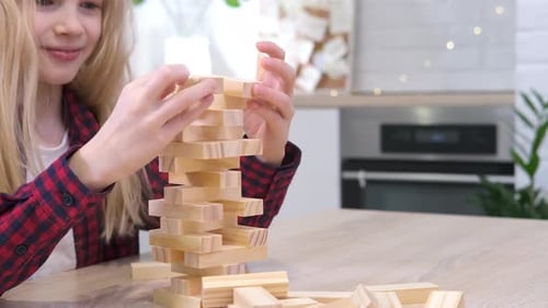 Kinder spielen zu Hause einen Turm zum Entfernen von Holzklötzen