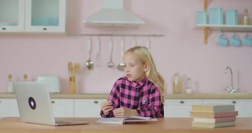 Girl Uses Laptop to Study at Kitchen Table