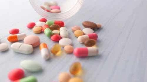 Close Up of Colorful Pills Spilling on White Background