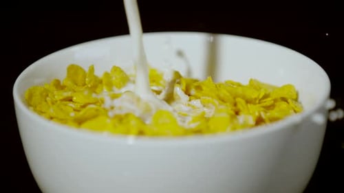 Milk Poured Over Corn Flakes in White Bowl