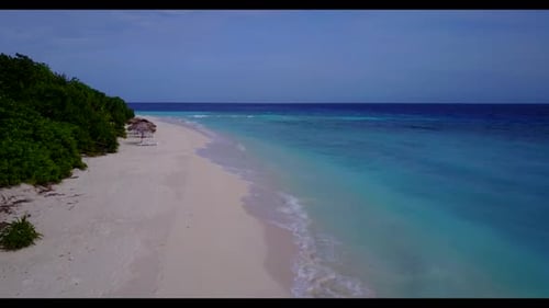 Aerial flying over landscape of exotic lagoon beach holiday by aqua blue ocean with white sand backg