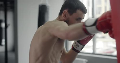 Boxer Mann in Rot Boxhandschuhe Punches Boxertasche in Zeitlupe Training im Boxclub 60p Prores