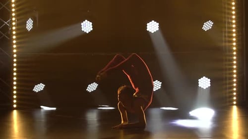 Eine flexible professionelle Sportlerin führt komplexe akrobatische Elemente der Rhythmischen Gymnastik aus