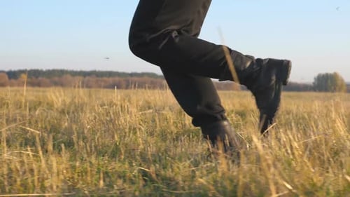Feet of Soldier in Black Boots Run Across Field and Stepping on Dry Grass. Male Athlete Is Training