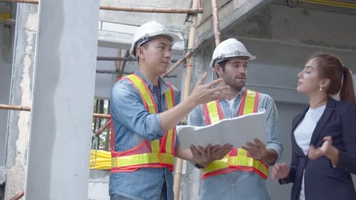 Young Asian engineers and caucasian engineer colleagues at site inspector and discuss together