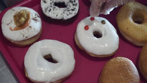 Decorating a glazed donut with colorful candies