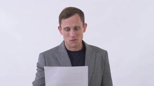 Portrait of Pleasant Man Reading Text Written on Piece of Paper Very Emotionally