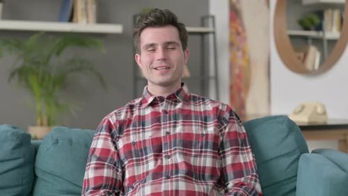 Young Man Sits and Speaks to Camera