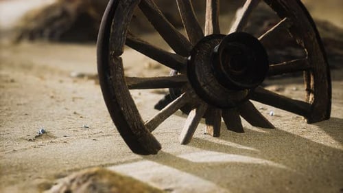 Rustic Wooden Wheel Half Buried in Desert Sand