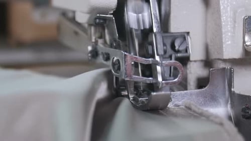 Une femme utilisant une machine à coudre pour coudre le tissu ensemble
