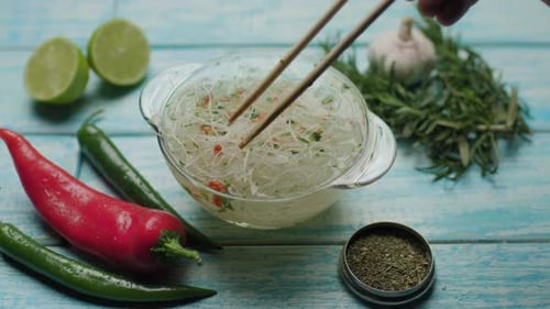 Cellophane Noodles in Broth Being Stirred With Chopsticks