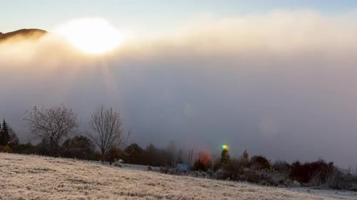 Sun Rises From Behind Mountain Top Fog Moves and Rises Up at Dawn on Summer Morning in Mountains
