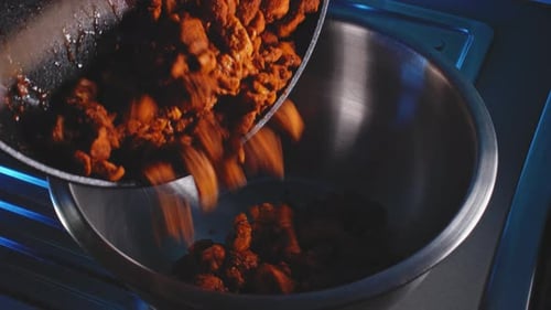 Transferring Cooked Chicken Breast From Pan Into Bowl. close up