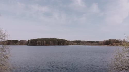 Vol entre les arbres au-dessus de la belle étendue de Blue Lake par une journée ensoleillée de printemps