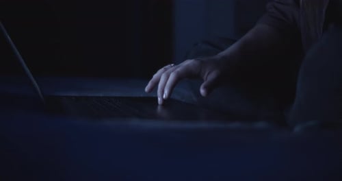 Woman Using Laptop in Dimly Lit Room