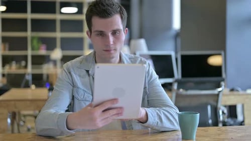 Focused Young Male Designer Using Tablet in Modern Office